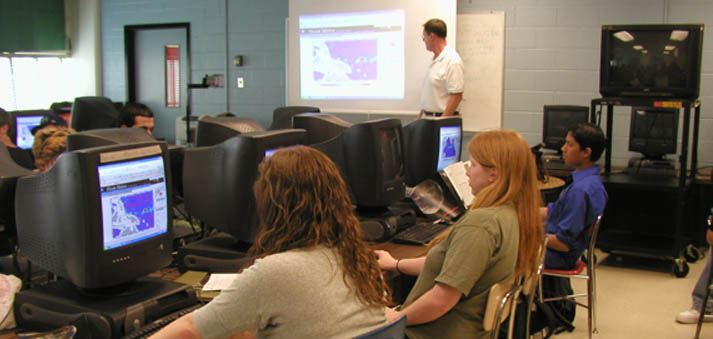 students in a classroom at walter johnson watching instructor david snyder describe a section of the website